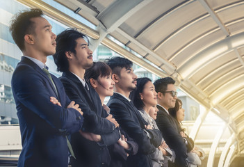 Obraz premium The young Asian business team stands with confidence and pride.