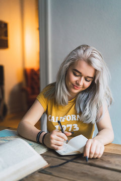 Pretty woman writing at table