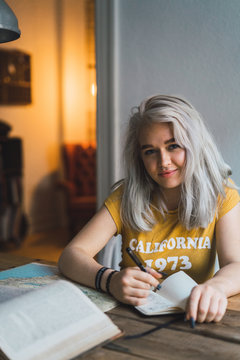 Pretty woman writing at table