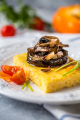 corn polenta with roasted mushrooms and eggplant, traditional Italian food with vegetables and thyme