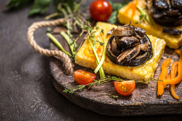 corn polenta with roasted mushrooms and eggplant, traditional Italian food with vegetables and thyme