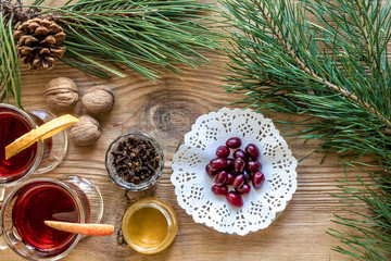 Two glass of mulled wine with cinnamon sticks, slice of oranges and apple, star anise on a wooden table