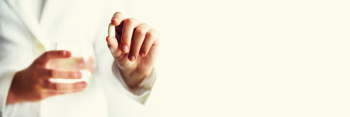 Doctor holding a glass of water with drug, pills, white background. Copy space. Banner. Medicine concept.