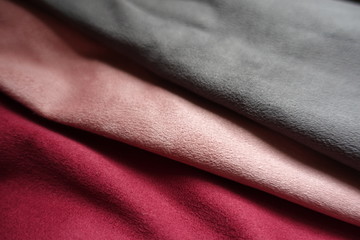 Artificial suede in grey, pink, red in soft folds