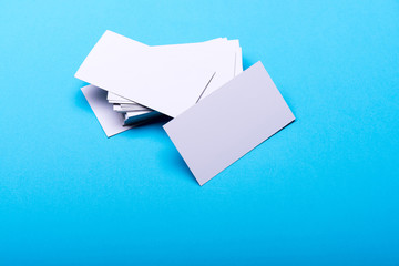 Business cards stack on cyan blue background.