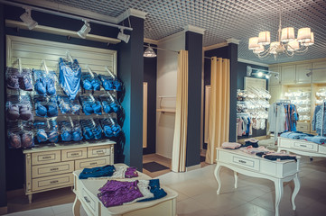 interior of a colorful modern underwear shop. Female mannequin in panties and bras and stands in a shopping center. Cozy light. Customer purchases, soft tone