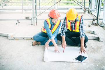 Engineer or Architect working at Construction Site with blueprint