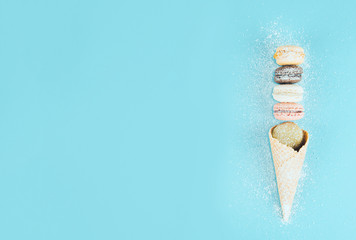 French cookies macaroons in a waffle cone with powdered sugar.