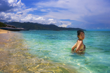 Obraz premium Asian Chinese woman having bath on Thailand island beach with amazing beautiful turquoise color water under summer blue sky