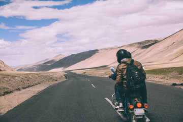 back view of two motorcyclists on mountain road in Indian Himalayas, Ladakh region