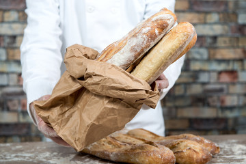 baker holding traditional bread french baguettes