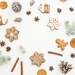 Round frame of Christmas gingerbread cookies, fir branches and anise on white background. Flat lay. top view. New year concept