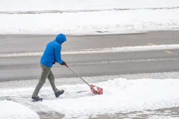 Man Clearing Snow From His Driveway With a Shovel