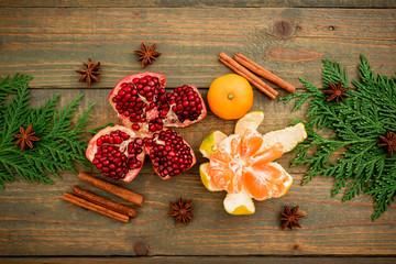 Christmas of New year concept. Fresh delicious garnet, citrus, cinnamon and anise on wooden table. Flat lay. Top view