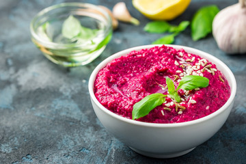 Healthy chickpea beetroot hummus on dark blue background. Selective focus, copy space. 