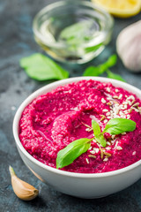 Gluten free vegan roasted beetroot hummus on dark blue background. Selective focus, copy space. 