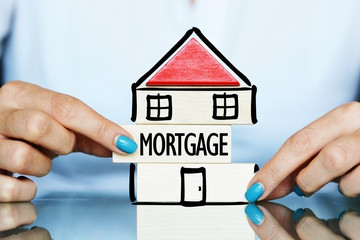 Release the mortgage of the property concept with young woman and house symbol on a table