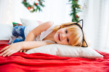 Obraz na płótnie Canvas Cute toddler girl on the bed with christmas decoration