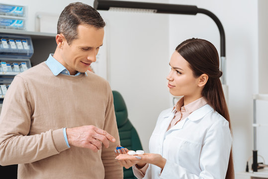 Portrait Of Ophthalmologist Show Contact Lens To Patient In Clinic