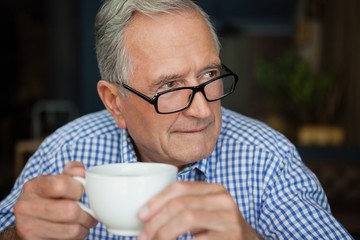 Thoughtful senior man sitting at cafe