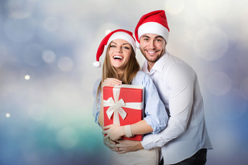 Christmas young couple with gifts on light background.