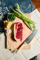 Raw steak with ingredients and Damascus steel knife