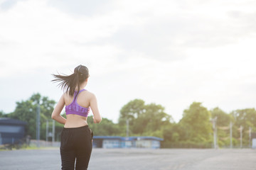 Naklejka premium Young woman runner is jogging on the street be running for exercise. Selective focus