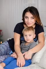 Merry Christmas celebration. Beautiful mom and little son at home near the Christmas tree. Christmas miracles. Happy New Year