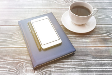 diary, smartphone, cup of coffee on a wooden background