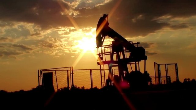 Rod crude oil pump in action during sunset time    