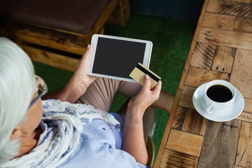 Obraz premium High angle view of woman holding tablet and credit card