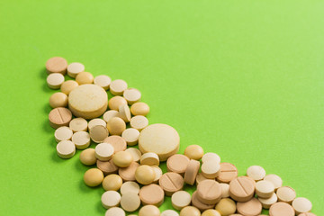 Heap of beige capsules on green table.