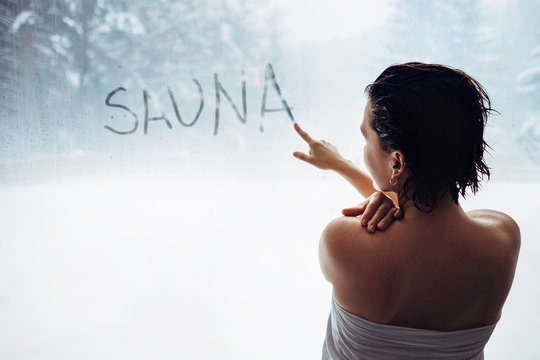 Woman wrote "sauna" word on misted window in welness zone