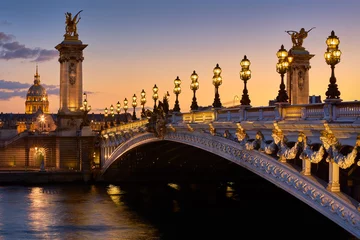 Brücke Pont Alexandre III und beleuchtete Laternenpfähle bei Sonnenuntergang mit Blick auf den Invalidendom. 7. Arrondissement, Paris, Frankreich © Francois Roux