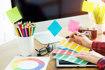 Woman working with color samples for selection. Graphic designer at work.