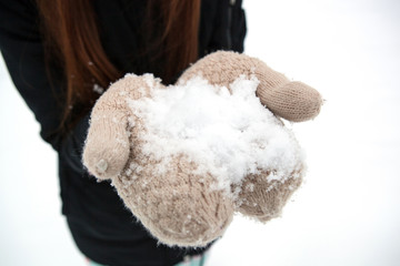 girl holding a pile of snow in her hands