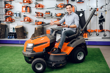 Fototapeta premium A man is sitting on a lawn mower.