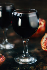 Fresh pomegranate juice in glass over black background.