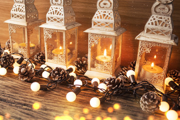 glow candle with lantern and bokeh with pine cone in christmas season concept