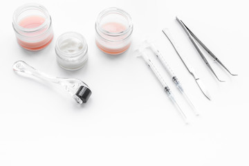 Dermatologist or cosmetologist accessories. Dermaroller, creams and mask, beauty injection, tools on white background copyspace