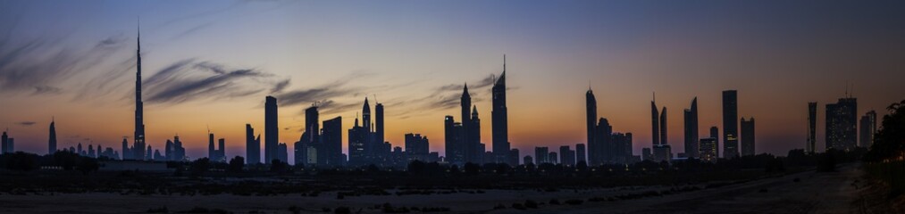 Panorama der Skyline von Dubai mit Silhouette der Wolkenkratzer im Gegenlicht fotografiert Abends bei klarem Himmel im November 2014