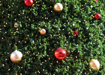 Obraz na płótnie Canvas Close up on Christmas tree with white lights, red and gold ball ornaments.