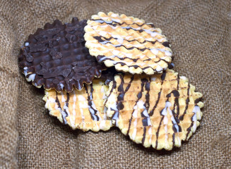 Round wafers biscuit with white and black chocolate isolated on sackcloth