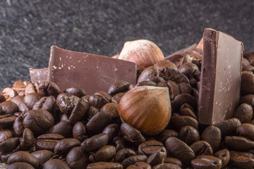 Close-up, roasted coffee seeds, tubberry, cinnamon sticks and chocolate.