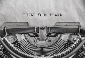 Build you brand words typed on a vintage typewriter in black and white. close up