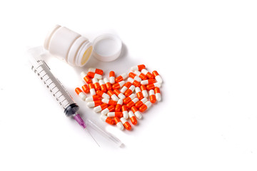Heart of capsules and  Syringe isolated on white background