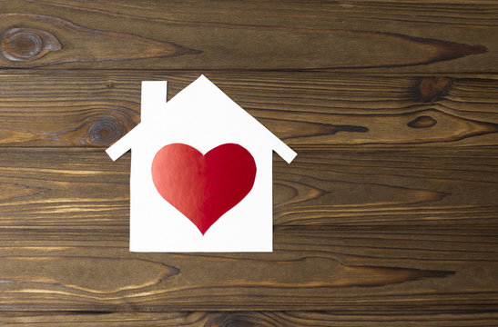 house made of paper, heart shape on a wooden background