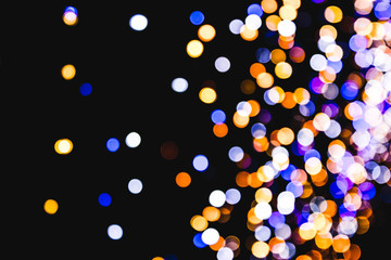 A variety of bokeh on a black background. Background of various unfocused glowing Christmas garlands.
