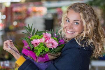 young woman buying flowers bouquet in florist shop