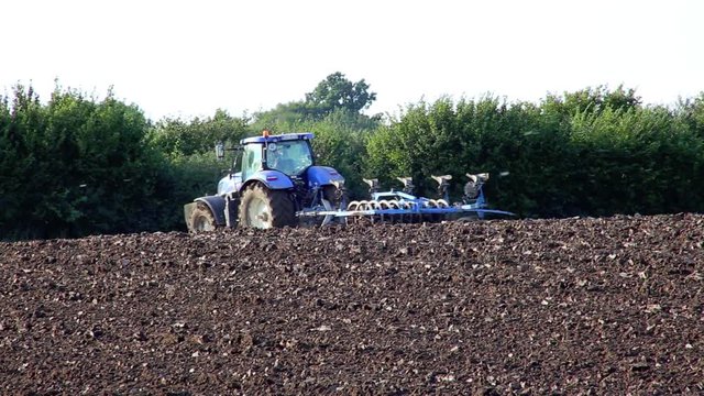 Traktor mit Pflug pfl&uuml;gt Acker um, Abendlicht Full HD Video 1080, 25 fps